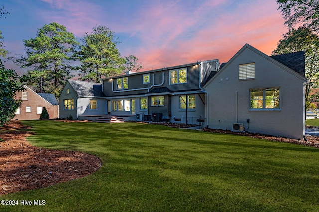 back house at dusk featuring a yard