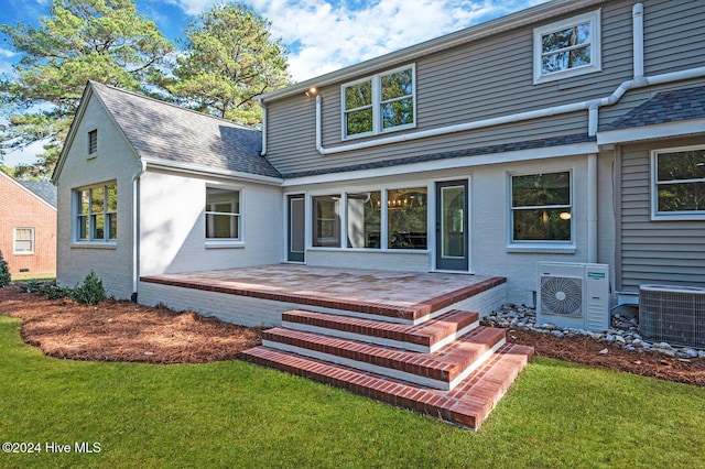 rear view of house featuring ac unit, a patio area, a yard, and central AC