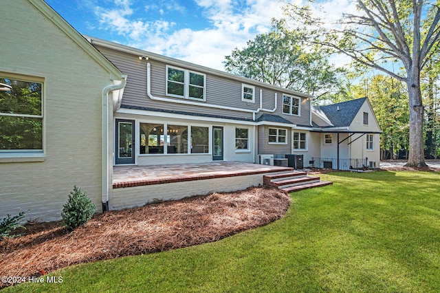 back of property with cooling unit, a patio area, and a yard