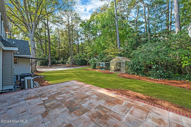 view of yard featuring an outbuilding, a patio, and central AC