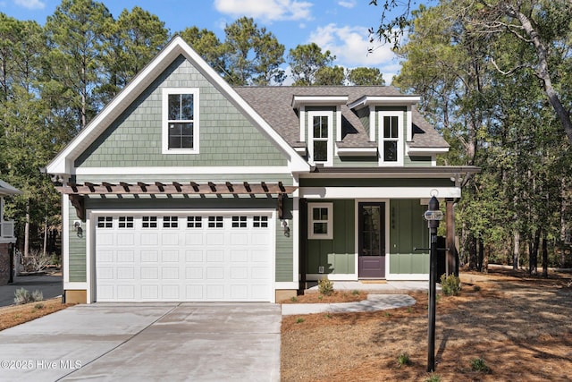 view of front facade featuring a garage, a shingled roof, concrete driveway, covered porch, and board and batten siding