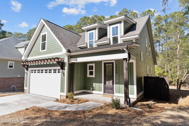 view of front of home featuring a shingled roof, covered porch, an attached garage, and concrete driveway