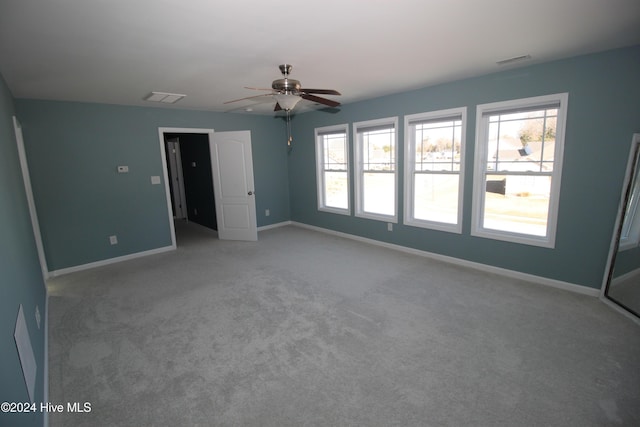 carpeted empty room featuring ceiling fan and a healthy amount of sunlight