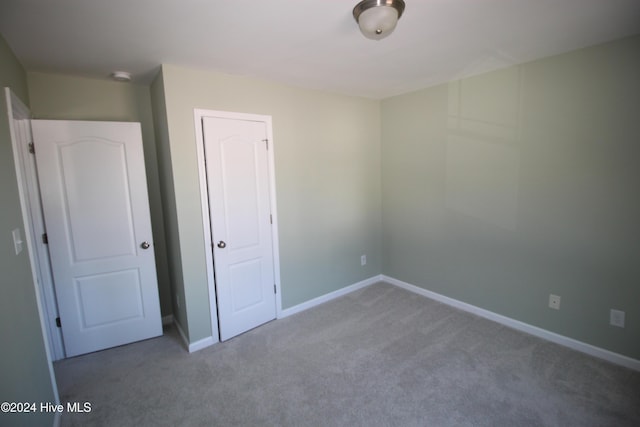 unfurnished bedroom with carpet flooring and a closet