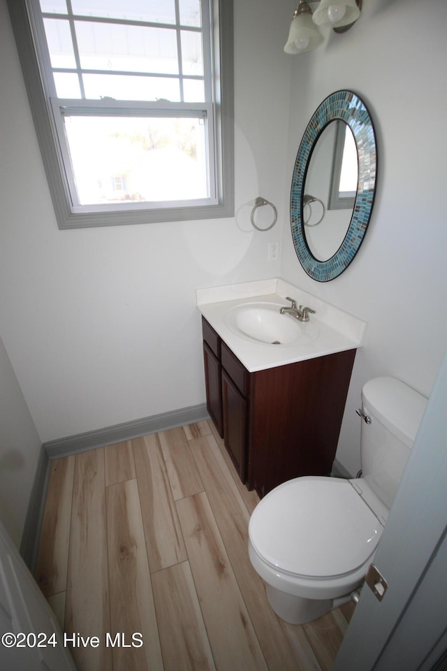 bathroom featuring wood-type flooring, vanity, and toilet