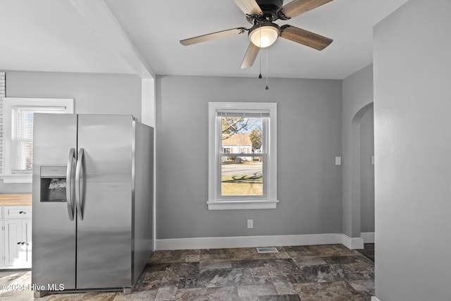 kitchen with white cabinets, ceiling fan, and stainless steel refrigerator with ice dispenser