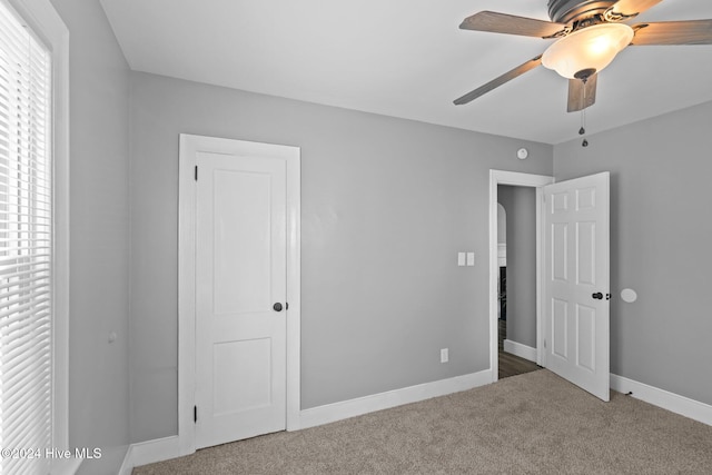 unfurnished bedroom with ceiling fan and carpet