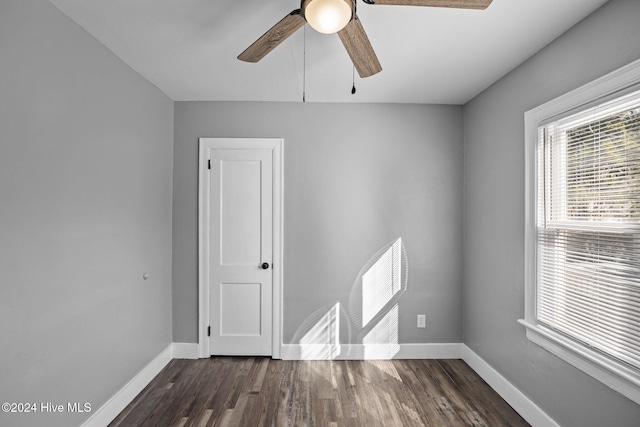 empty room with ceiling fan and dark wood-type flooring