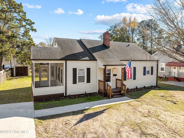 bungalow with a sunroom and a front lawn