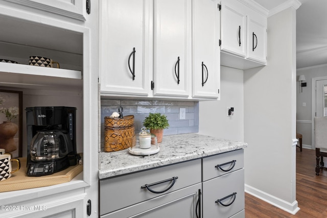 room details featuring tasteful backsplash, wood-type flooring, and crown molding