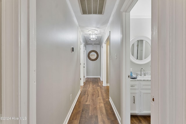 corridor featuring sink, dark wood-type flooring, and ornamental molding