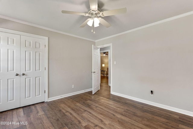 unfurnished bedroom featuring dark hardwood / wood-style flooring, crown molding, a closet, and ceiling fan