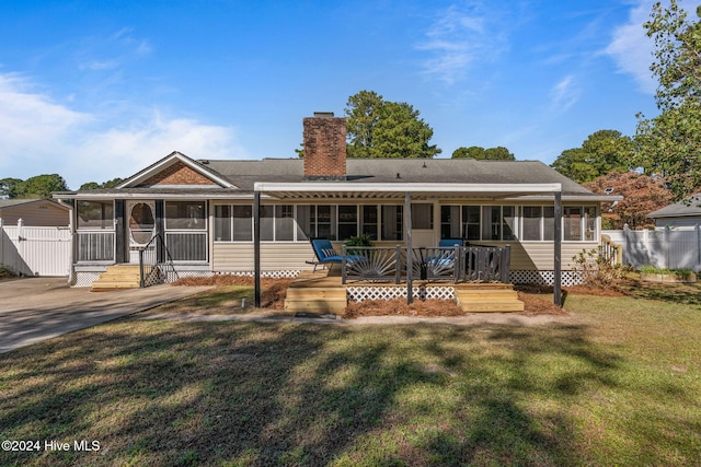 view of front facade featuring a wooden deck, a sunroom, and a front yard