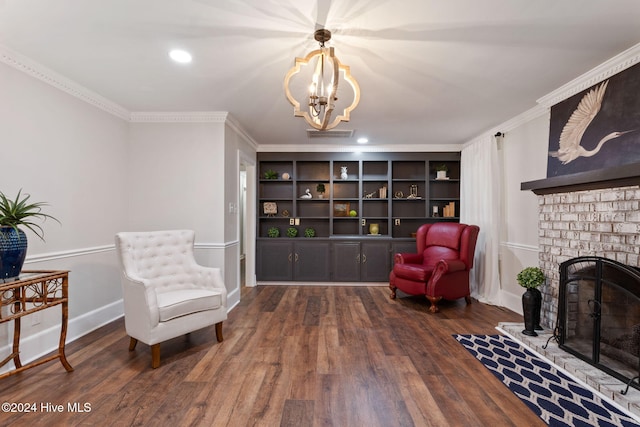 living area with ornamental molding, dark hardwood / wood-style floors, a chandelier, and a brick fireplace