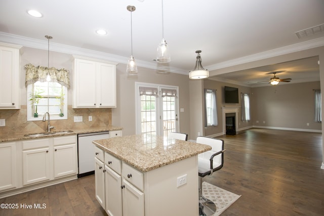 kitchen with white cabinets, sink, white dishwasher, and decorative light fixtures