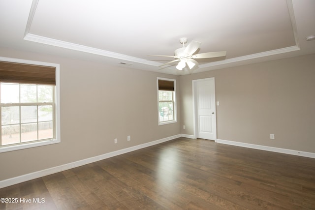 empty room with dark hardwood / wood-style floors, ceiling fan, and a raised ceiling