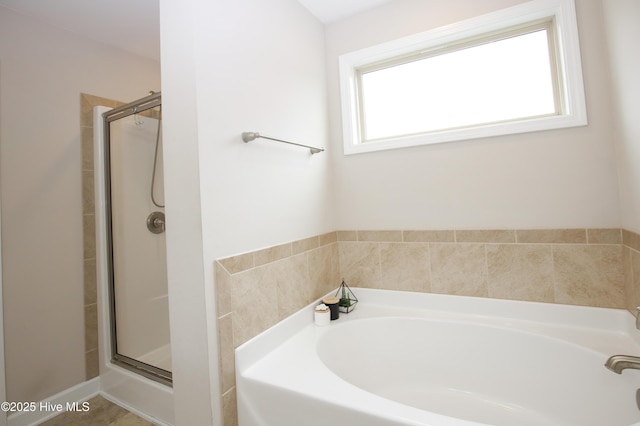 bathroom with tile patterned flooring, a healthy amount of sunlight, and shower with separate bathtub