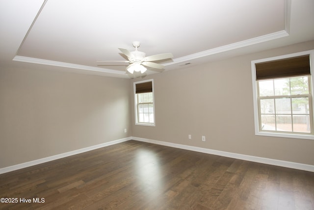 spare room featuring dark hardwood / wood-style floors, a raised ceiling, ceiling fan, and crown molding