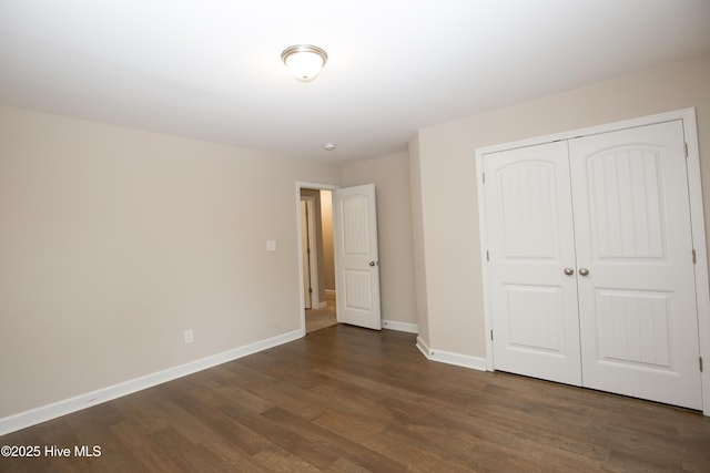 unfurnished bedroom featuring dark hardwood / wood-style floors and a closet