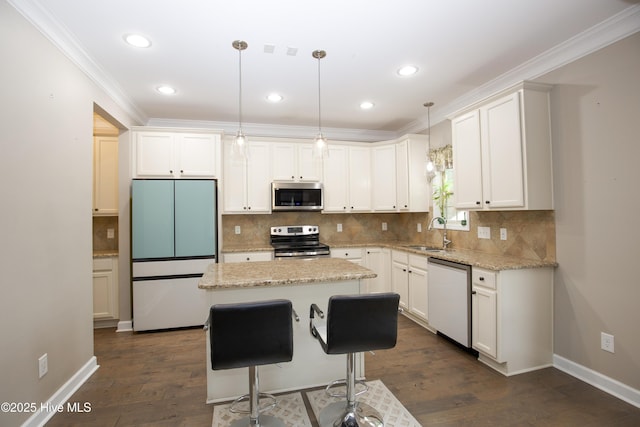 kitchen featuring a center island, sink, decorative light fixtures, white cabinetry, and stainless steel appliances