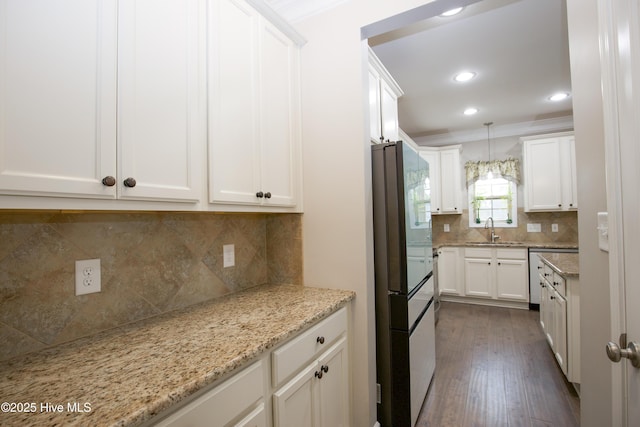 kitchen with white cabinets, sink, ornamental molding, decorative light fixtures, and light stone counters