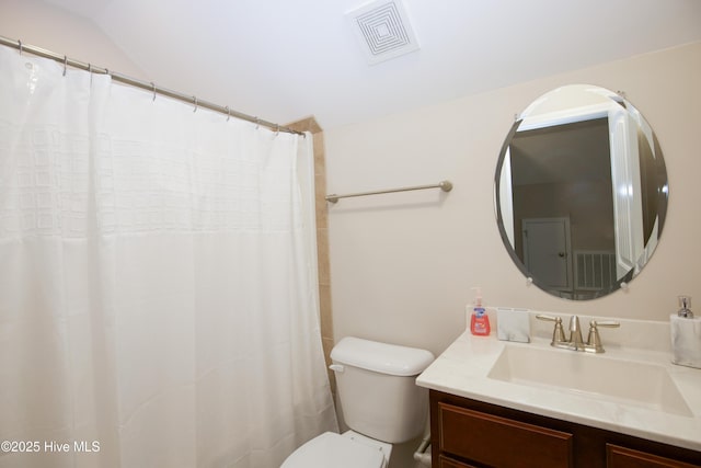 bathroom with vanity, toilet, and lofted ceiling