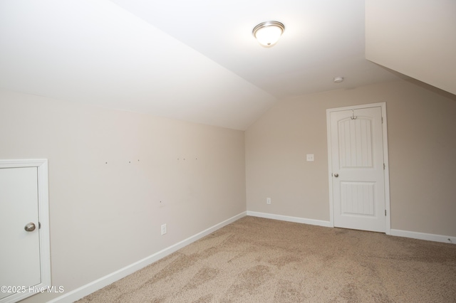 additional living space featuring carpet and vaulted ceiling