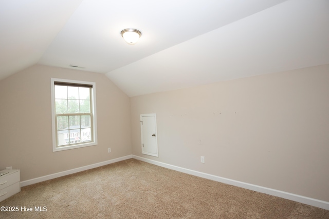 additional living space with carpet flooring and vaulted ceiling