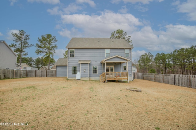 rear view of property featuring a deck and a yard