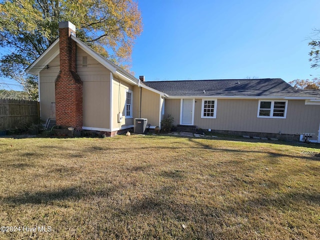 back of house featuring cooling unit and a lawn