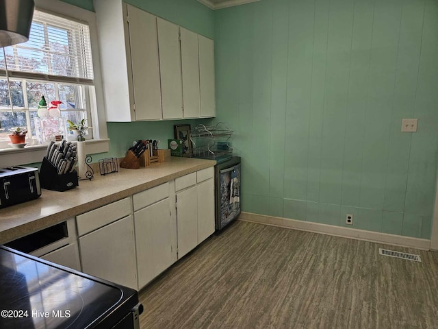 kitchen featuring white cabinets, hardwood / wood-style floors, and black electric range oven