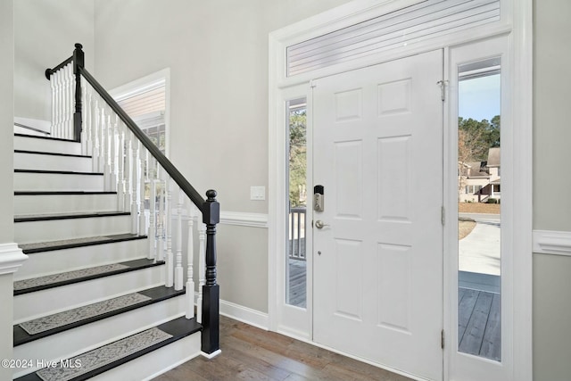 entryway with a healthy amount of sunlight and dark hardwood / wood-style floors