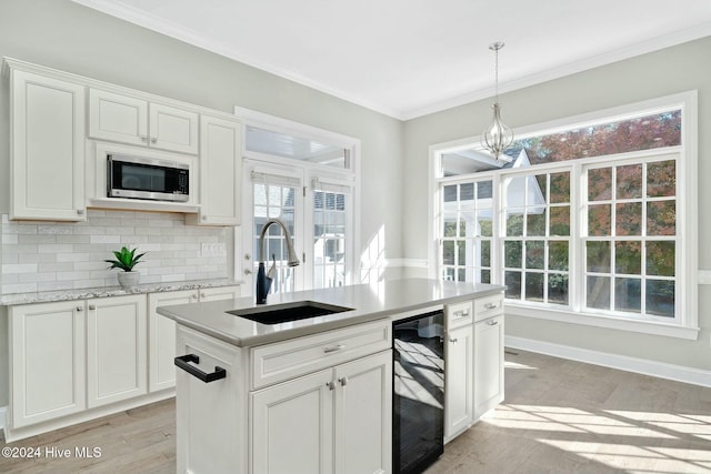 kitchen featuring white cabinetry, sink, light hardwood / wood-style floors, and plenty of natural light