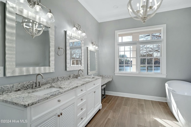 bathroom with vanity, wood-type flooring, a tub to relax in, and an inviting chandelier