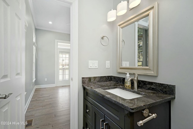 bathroom with hardwood / wood-style floors, vanity, and ornamental molding