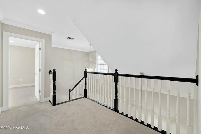 staircase featuring carpet floors, ornamental molding, and a chandelier