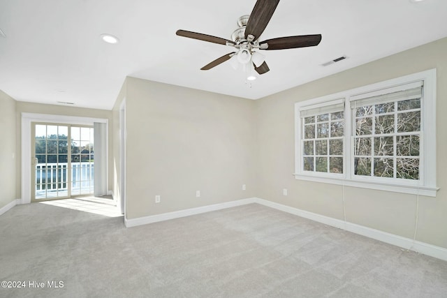 carpeted spare room featuring ceiling fan