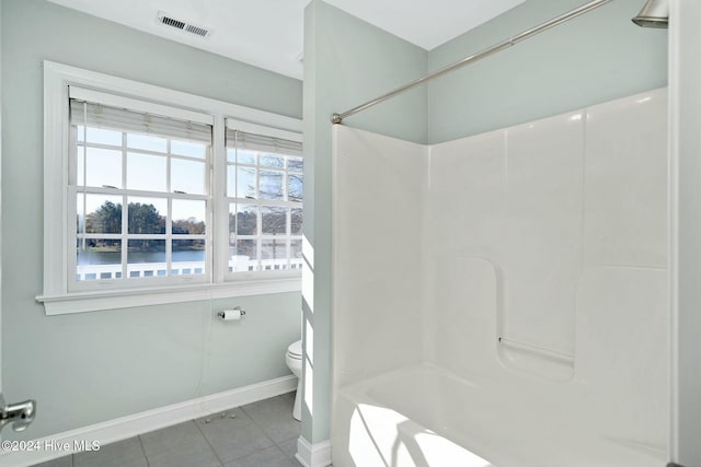 bathroom with tile patterned flooring, toilet, and shower / washtub combination