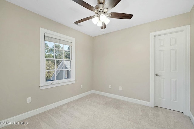 carpeted spare room featuring ceiling fan