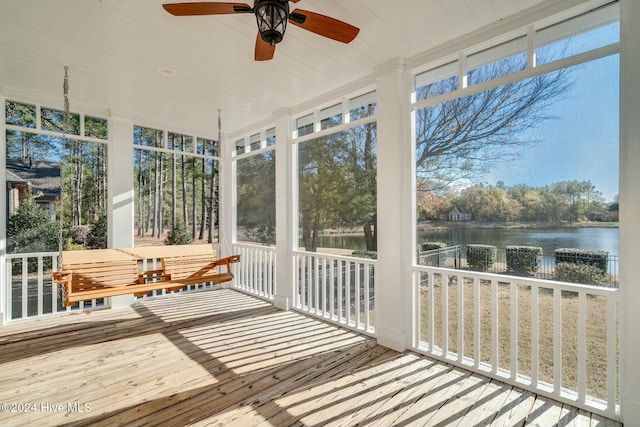 sunroom with a water view and ceiling fan