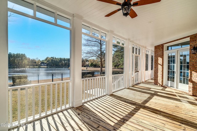 unfurnished sunroom with ceiling fan, a water view, and wood ceiling