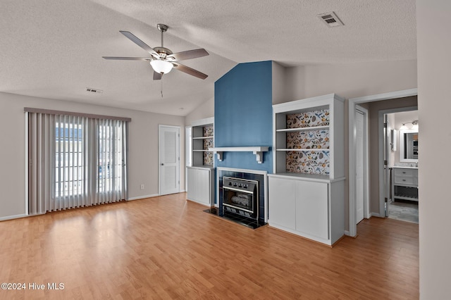 unfurnished living room featuring a textured ceiling, ceiling fan, vaulted ceiling, and hardwood / wood-style flooring