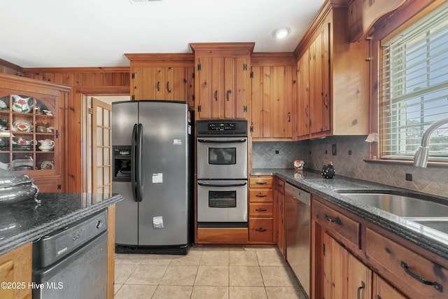 kitchen with sink, backsplash, appliances with stainless steel finishes, light tile patterned floors, and ornamental molding