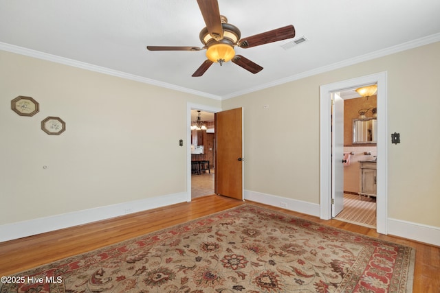 spare room with ceiling fan with notable chandelier, light wood-type flooring, and crown molding