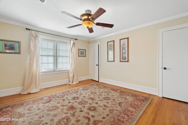 empty room featuring hardwood / wood-style floors, ceiling fan, and crown molding