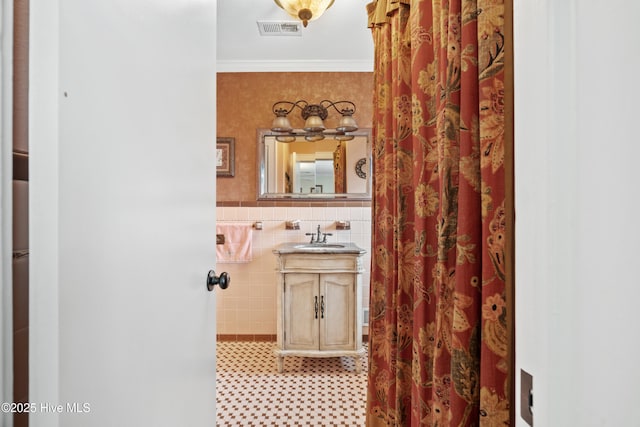 bathroom with vanity, tile walls, and crown molding