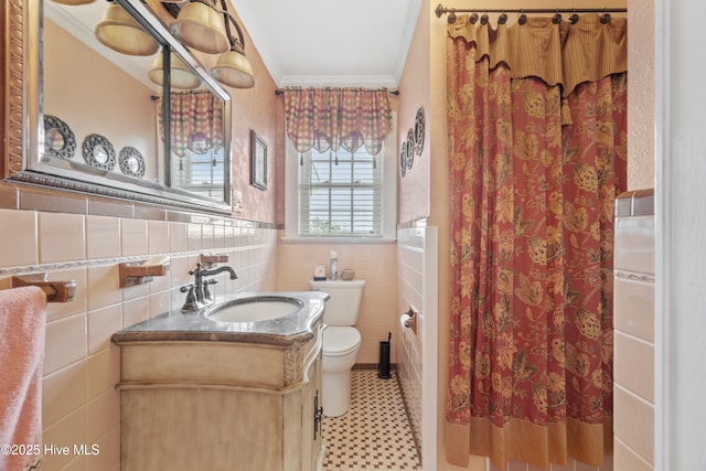 bathroom featuring crown molding, vanity, tile walls, and toilet