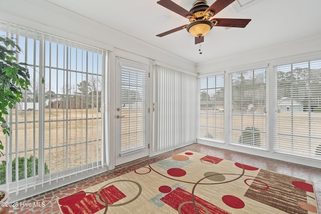 unfurnished sunroom with ceiling fan