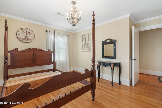 bedroom with an inviting chandelier, light hardwood / wood-style flooring, and crown molding