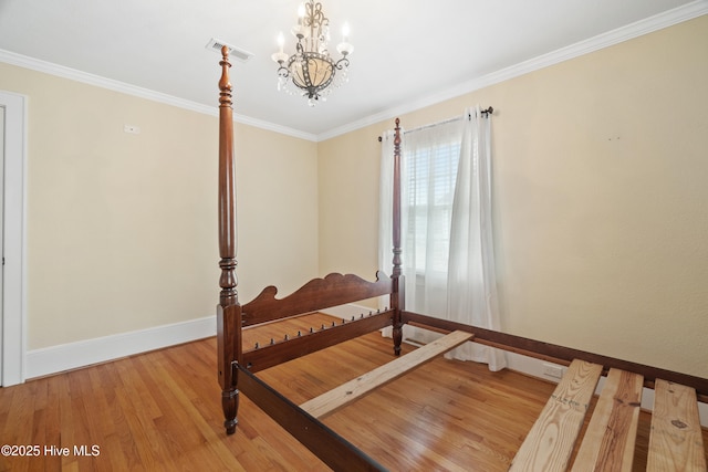 bedroom featuring hardwood / wood-style flooring, an inviting chandelier, and ornamental molding